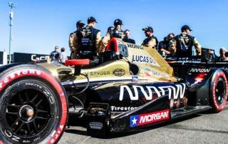 Pit crew standing beside Formula 1 car