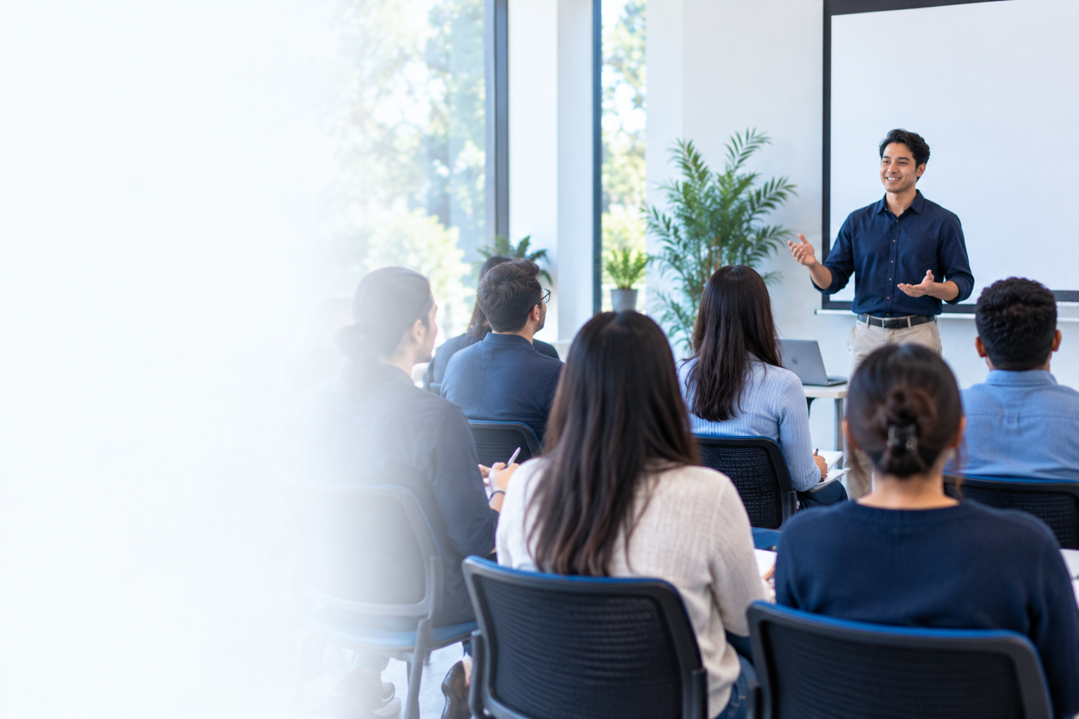 A trainer presenting to a small group in a bright meeting room